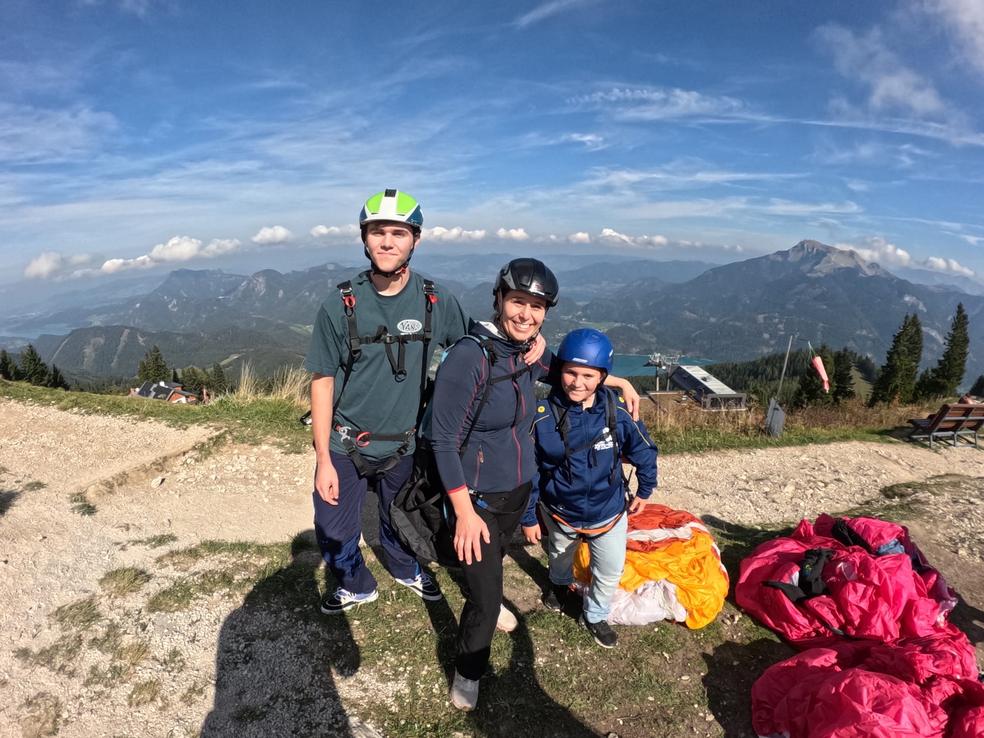 Drei Personen mit Paragleitausrüstung am Startplatz